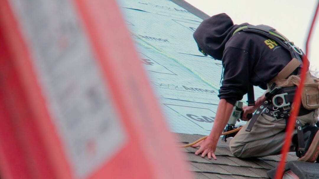 a local roofer works on a house roofing installation in Simcoe County